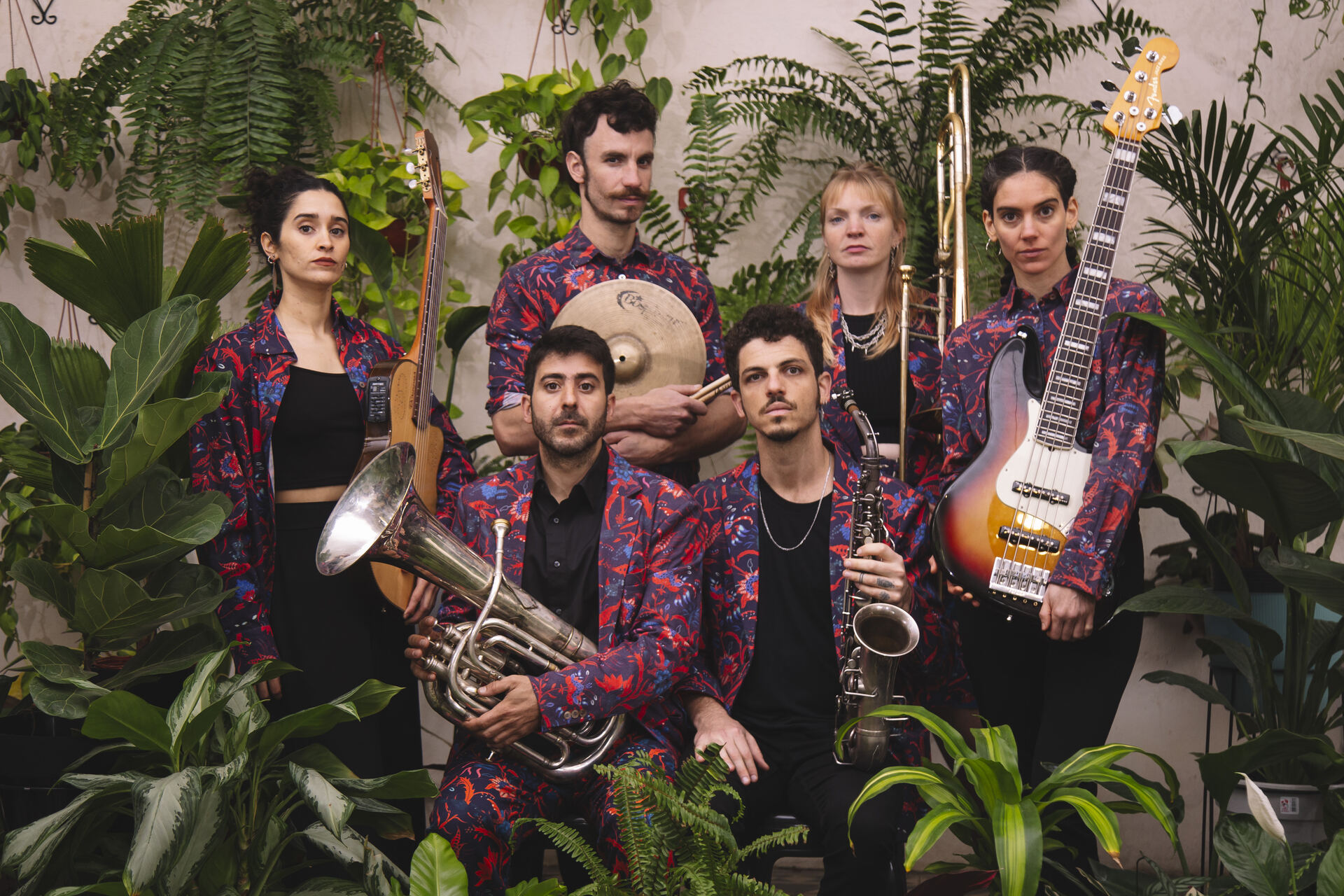 Desmadre Orkesta in patterned suits, posing with their instruments