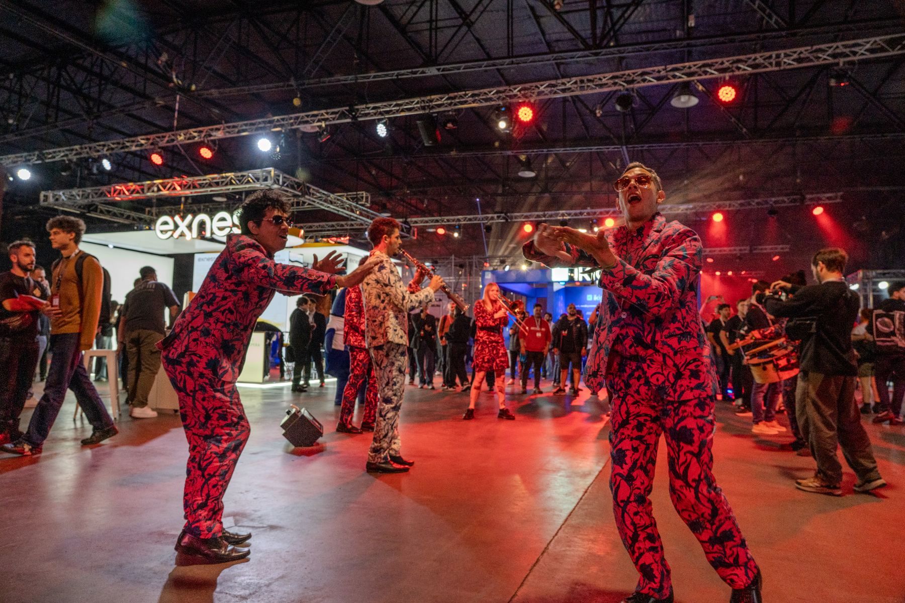 Desmadre XL musicians in patterned suits dancing among the guests at a corporate event